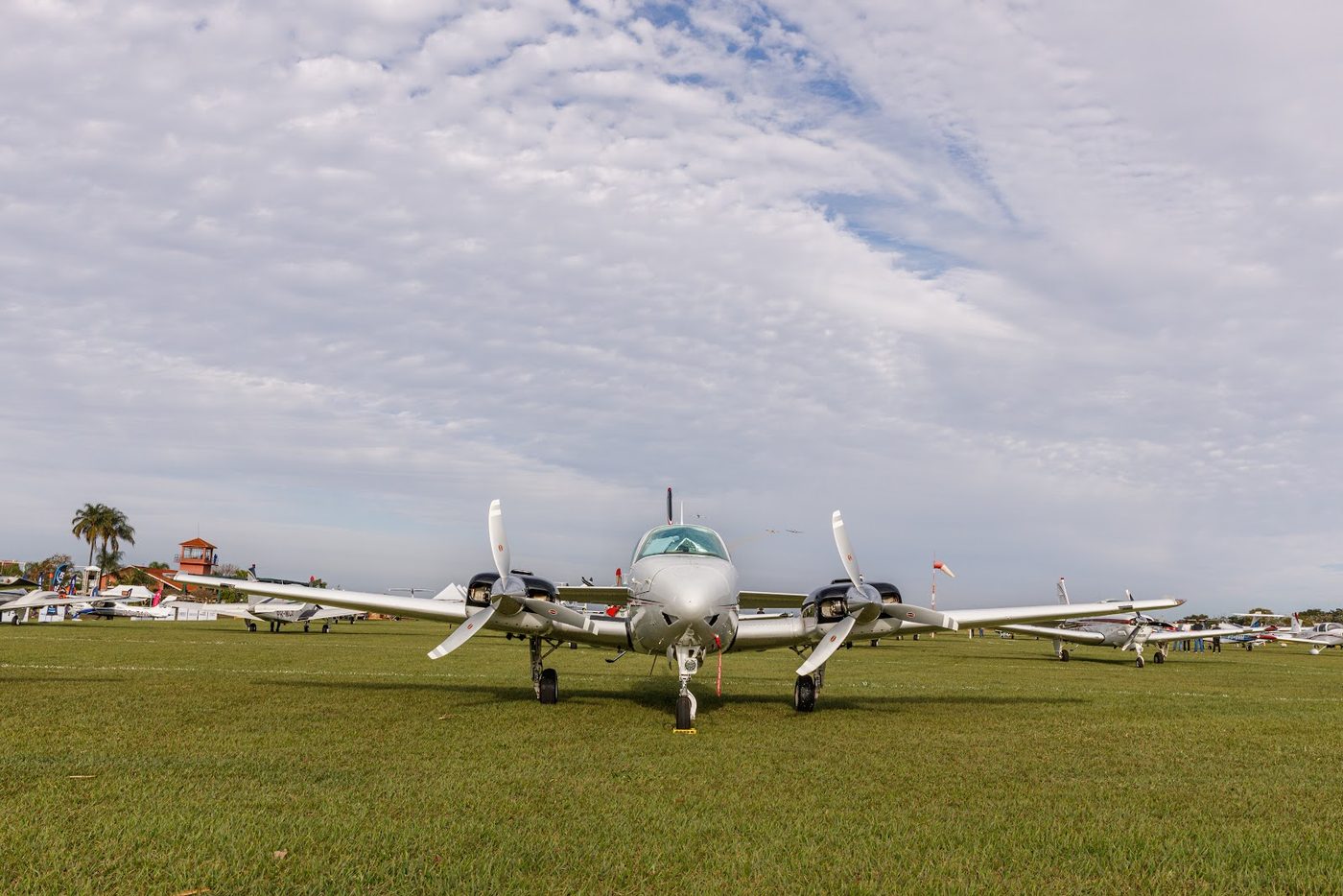 Aeronave bimotor Beechcraft estacionada na pista de grama